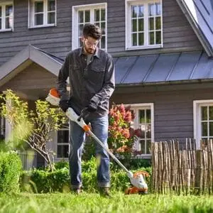 a man operating the STIHL FSA 50 Cordless Grass Trimmer in a garden