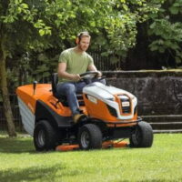 a man driving a STIHL RT 6127 Petrol Ride-on Lawn Mower across a lawn