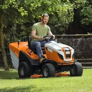 a man driving the STIHL RT 6127 Petrol Ride-on Lawn Mower across a lawn