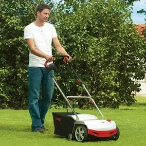 a man dressed in jeans and a white t-shirt, scarifying a lawn with the AL-KO 38 E Electric Scarifier