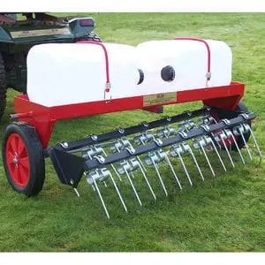 the SCH DTC 40-Inch Dethatcher being towed across a lawn by a compact tractor