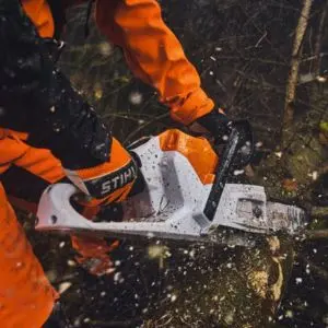 Close-up of the STIHL MSA 260 C-O cordless chainsaw cutting through timber with wood chips flying.
