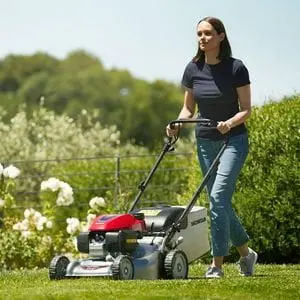 a woman mowing a lawn with the Honda HRG466 mower