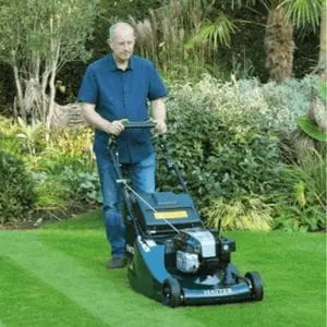 a man mowing a striped lawn using the Hayter Harrier 56 BBC VS Petrol Lawnmower