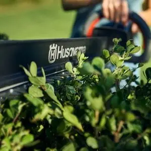 a close up of someone using the Husqvarna Aspire™ H50-P4A Cordless Hedge Trimmer to shape the top of a hedge