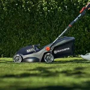 someone pushing the Husqvarna Aspire™ LC34-P4A Cordless Lawn Mower across a lawn