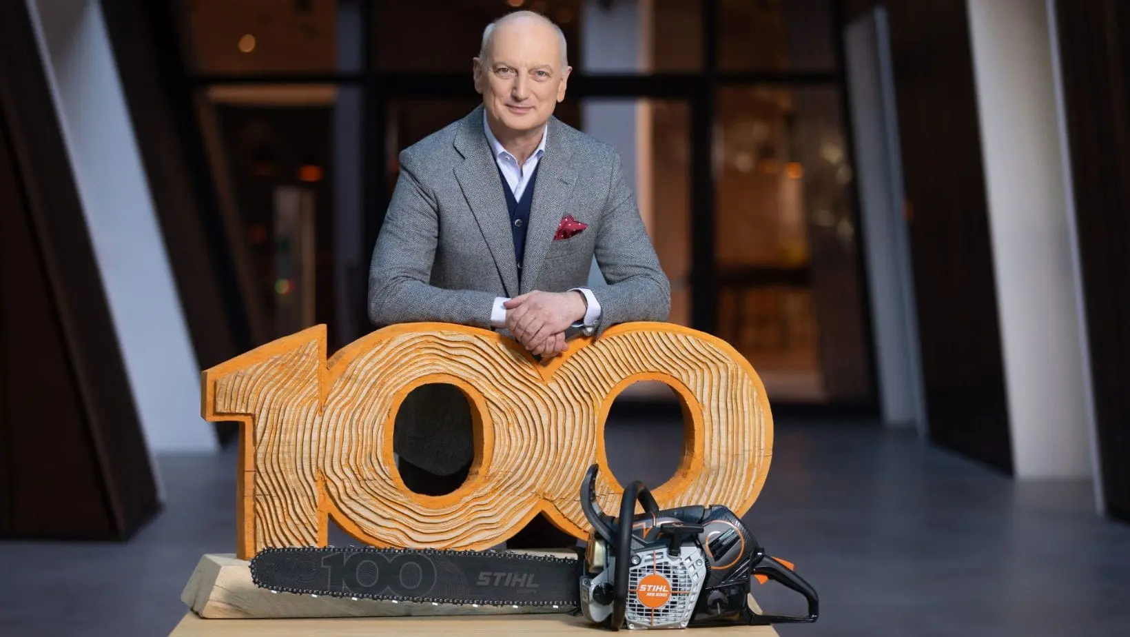 STIHL 100 (1) Dr Nikolas Stihl stood behind a STIHL MS 500i Centennial Edition Chainsaw and sculpture of the number 100