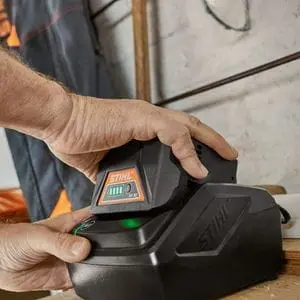 a man putting a STIHL battery into a charger