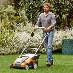 a man mowing a lawn using a STIHL cordless lawnmower