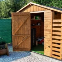 an apex wooden shed with its door open to reveal a lawnmower and other items