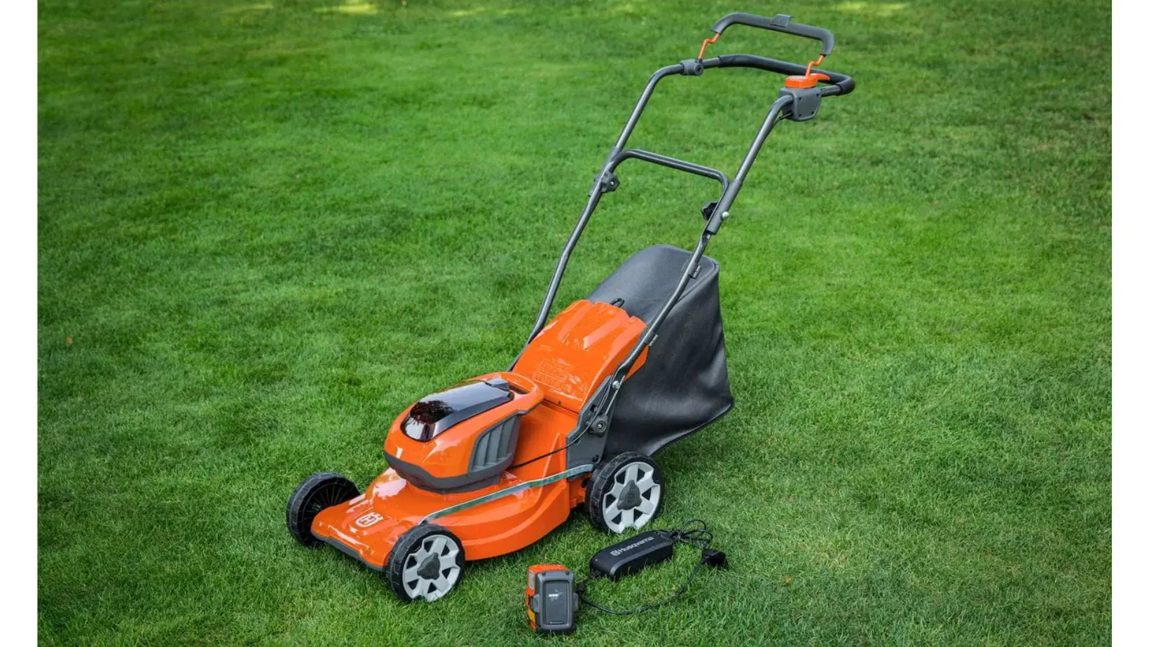 Husqvarna LC137i with battery and charger (1) a Husqvarna LC137i Cordless Mower, with battery and charger, together on a lawn