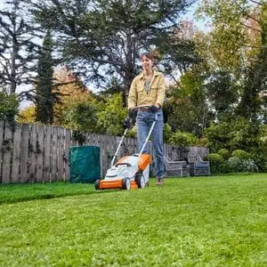 a woman mowing a lawn using the STIHL RMA 235 Cordless Lawn Mower