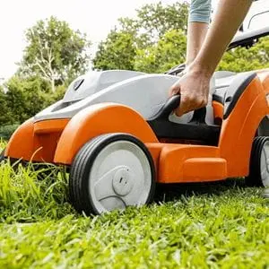someone adjusting the cutting height on a STIHL lawnmower