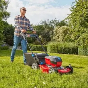 a man wearing sunglasses, mowing a large lawn using the Toro eS55AST eRecycler™ 60V Cordless Self-Propelled Lawn Mower