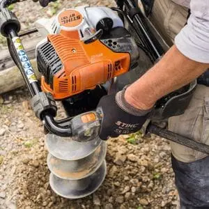 a close up of someone operating the STIHL BT 131 Petrol Earth Auger