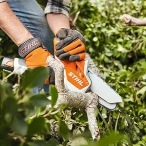 someone wearing STIHL gloves, using the STIHL GTA 26 Cordless Pruner to cut a tree branch