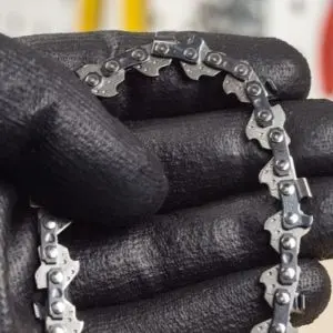 a close up of someone wearing black gloves, holding a chainsaw chain
