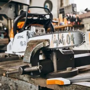 a STIHL chainsaw with Light 04 guide bar, in a vice on a workshop bench