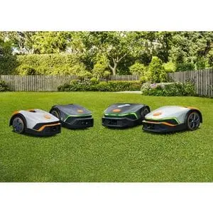 four STIHL iMow robotic mowers on a lawn, which is surrounded by fencing