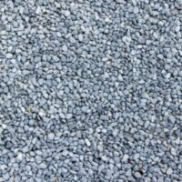 Close-up of small grey gravel stones covering a driveway surface.